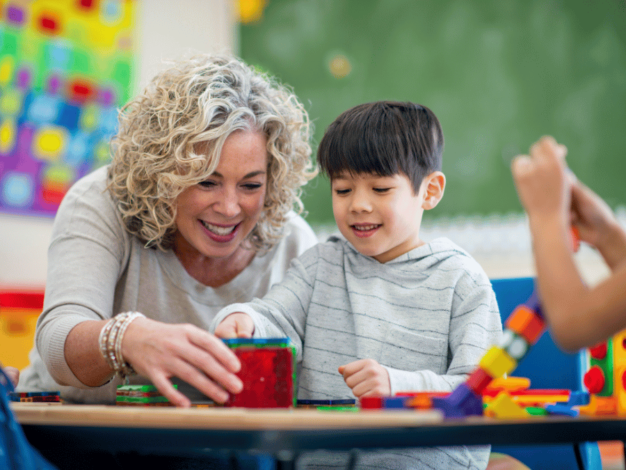 A caring support counsellor helping a child take part in an activity
